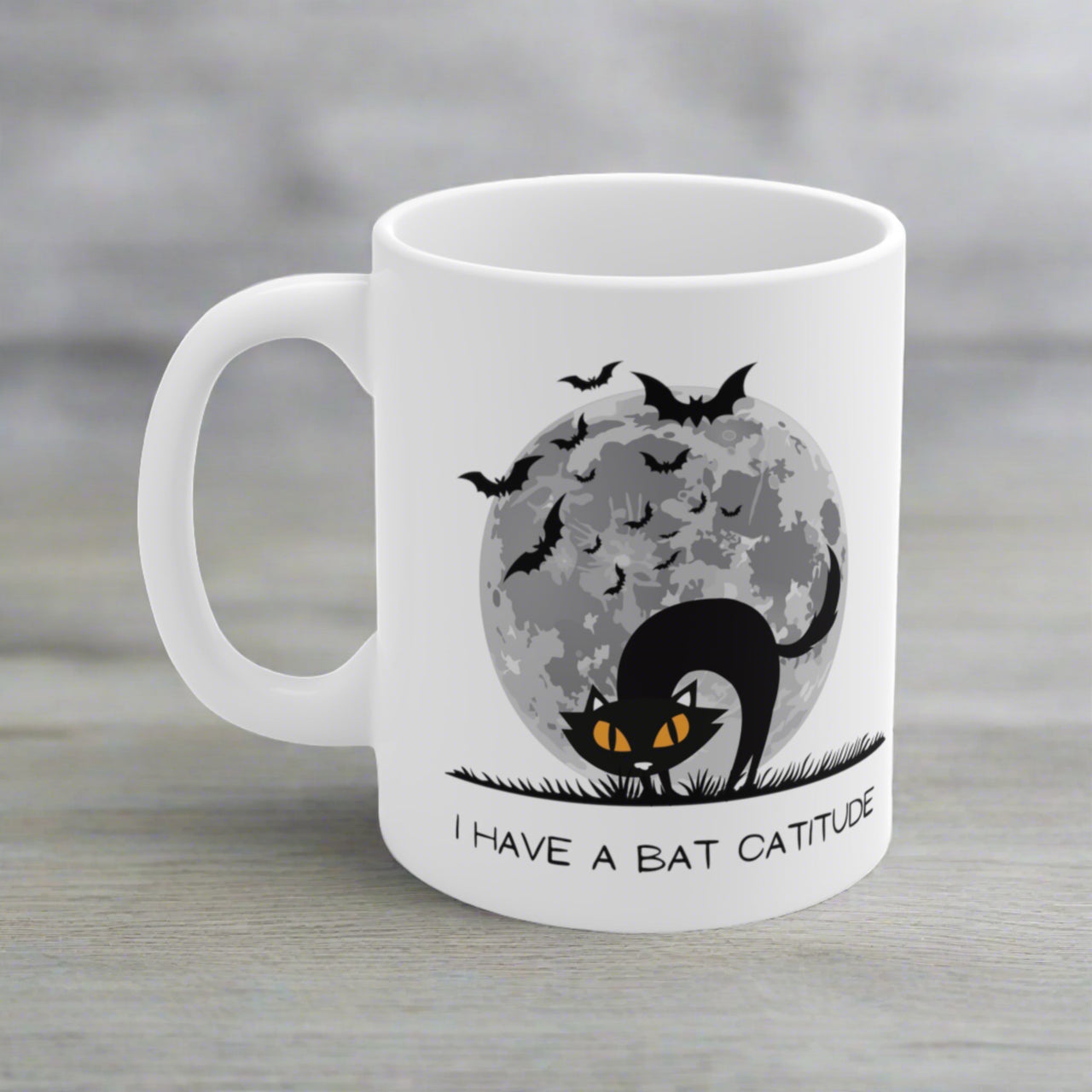 funny halloween cat mug with the image of a black cat, bats, and a full moon, and the text I have a bat catitude